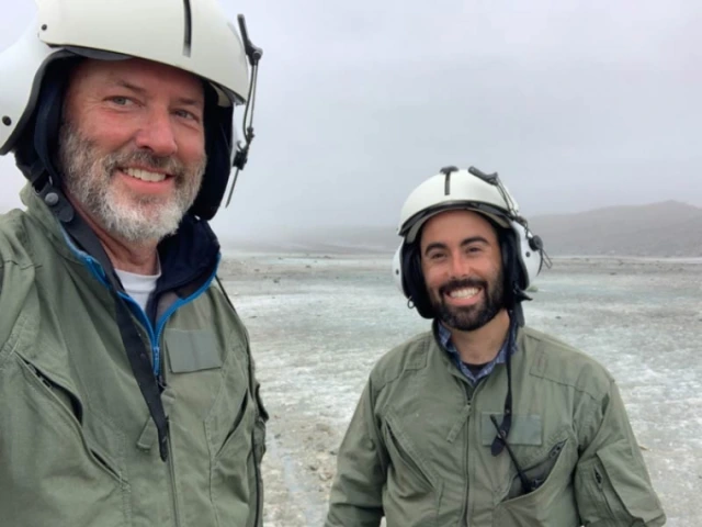 Jack Holt (left) and Brandon Tober await a helicopter ride